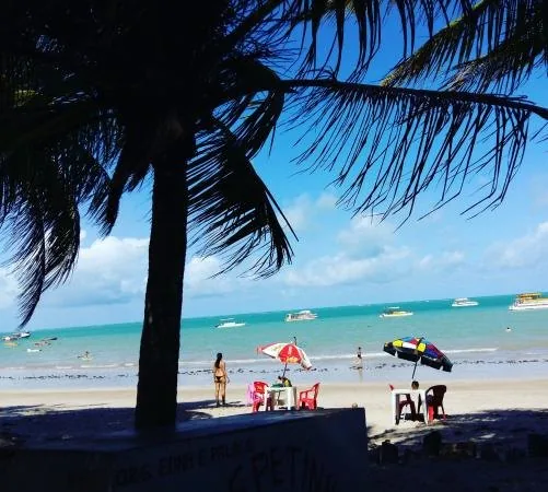 Faixa de areia e mar esverdeado da Praia do Poço, em Cabedelo
