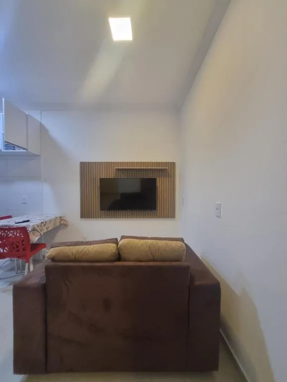 Sala de estar do flat, com sofá e TV